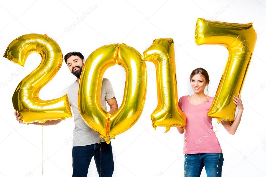 Couple holding golden balloons