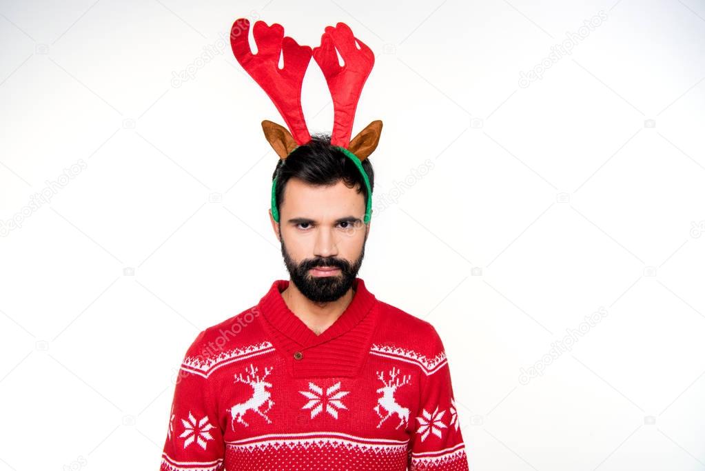 Serious man in reindeer antlers headband