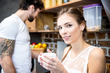 Gülümseyen kadın bardağı tutuyor.