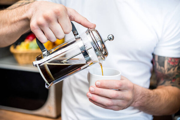 Man pouring coffee in cup