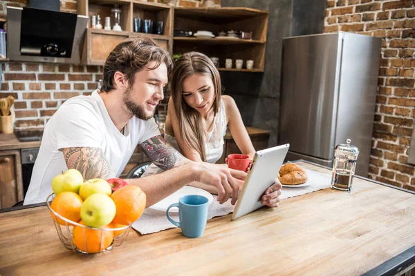 Pareja usando tableta digital en la cocina —  Fotos de Stock