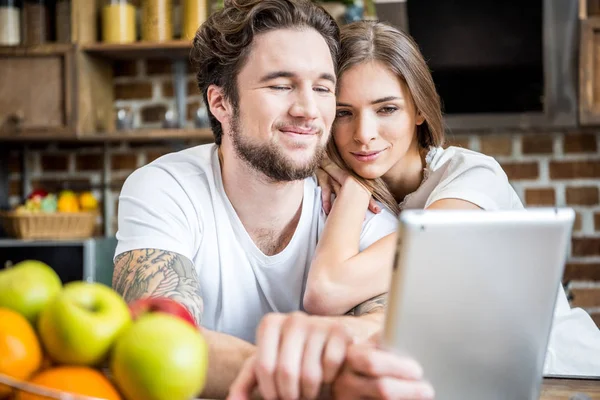 Pasangan menggunakan tablet digital di dapur — Stok Foto