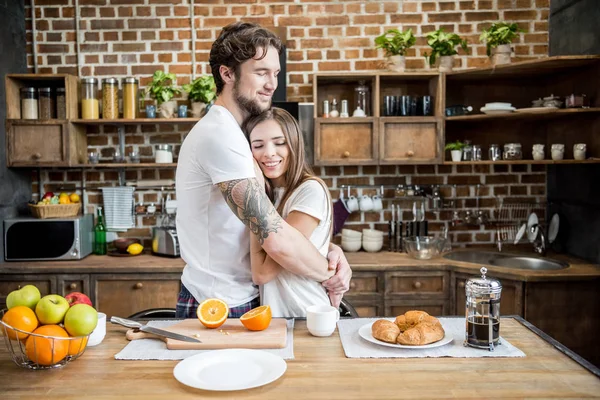 Paar knuffels in de keuken — Stockfoto