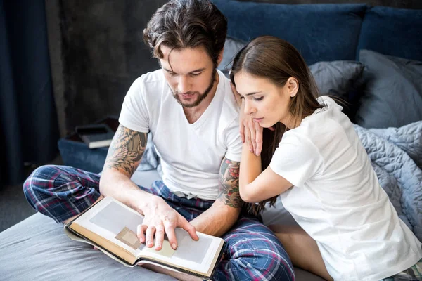 Couple reading book in bedroom — Stock Photo, Image