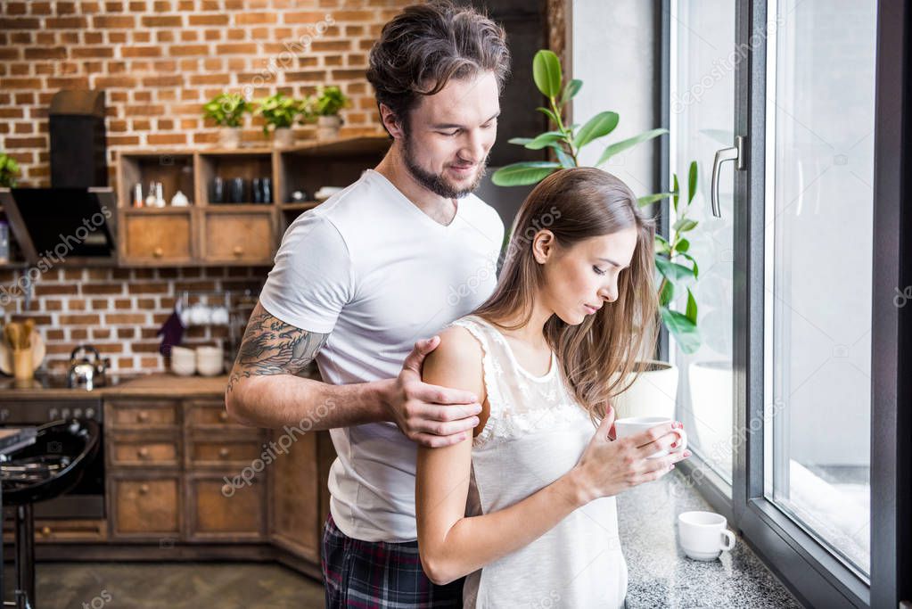 Smiling man hugging woman