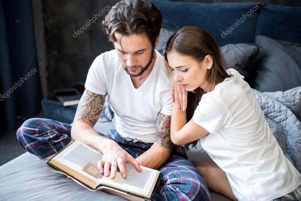 Couple reading book in bedroom