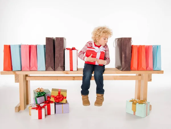 Enfant avec pile de boîtes-cadeaux — Photo de stock