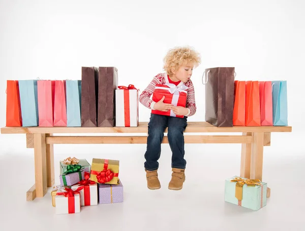 Kid with pile of gift boxes — Stock Photo