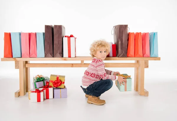 Niño con pila de cajas de regalo - foto de stock