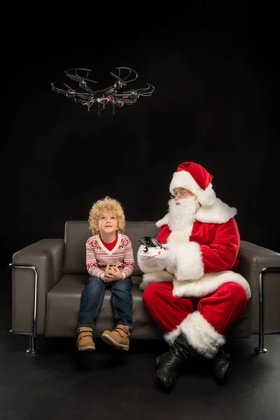 Santa Claus usando dron hexacopter con niño - foto de stock