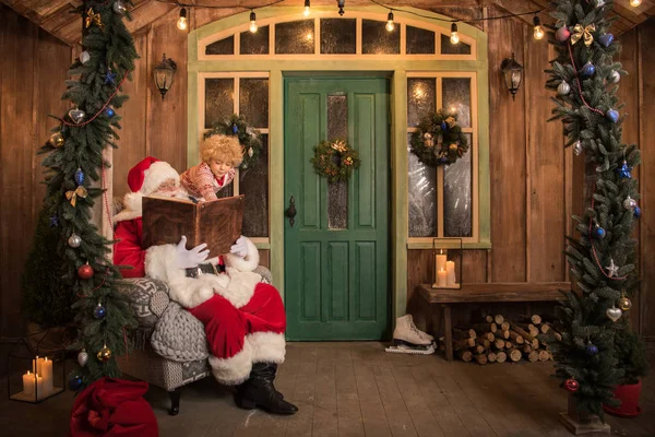 Santa Claus con libro de lectura infantil - foto de stock