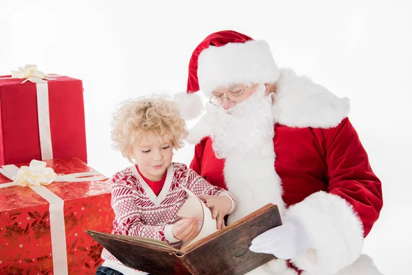 Santa Claus y el niño leyendo el libro juntos - foto de stock
