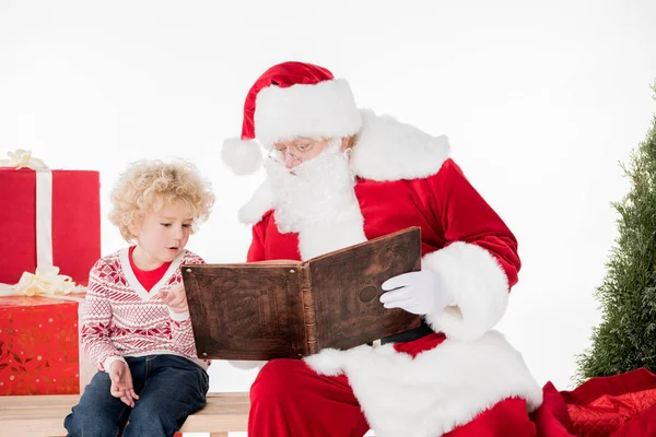 Santa Claus y el niño leyendo el libro juntos - foto de stock