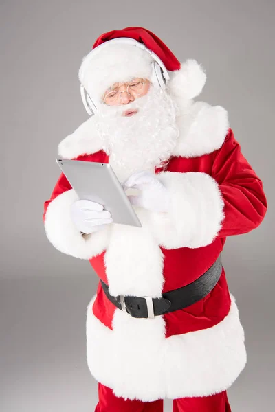 Santa Claus escuchando música con auriculares - foto de stock