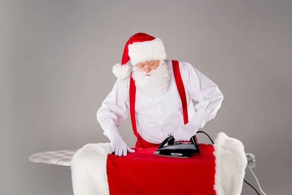 Santa Claus ironing coat — Stock Photo