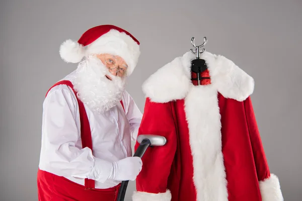 Santa Claus cleaning coat — Stock Photo