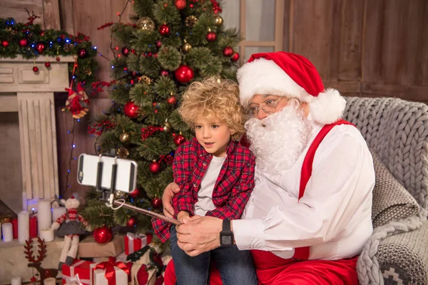 Санта Клаус с ребенком, делающим селфи — стоковое фото
