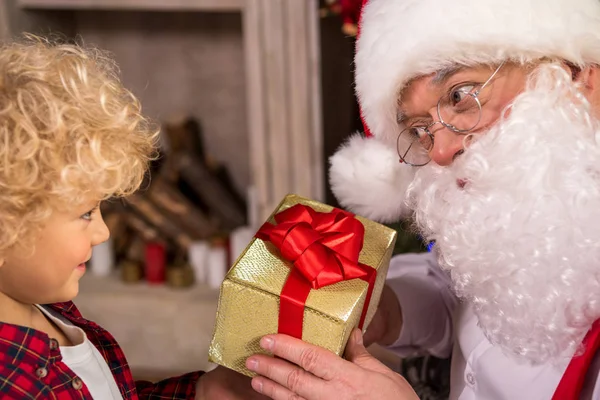 Санта-Клаус дарит подарок ребенку — стоковое фото
