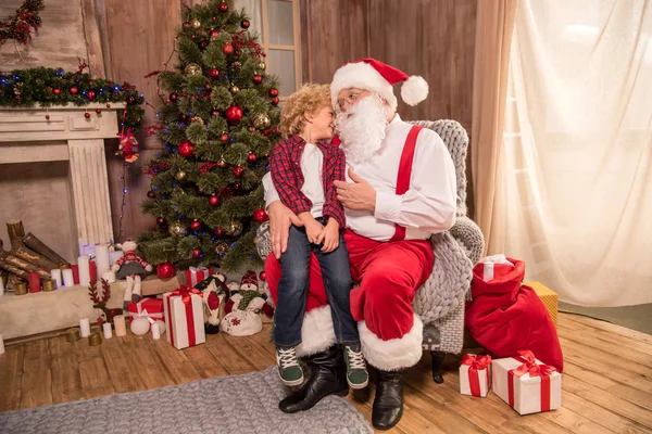 Санта-Клауса з дитиною на коліні — стокове фото