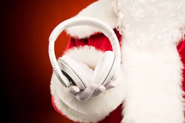 Santa Claus mano mostrando auriculares - foto de stock