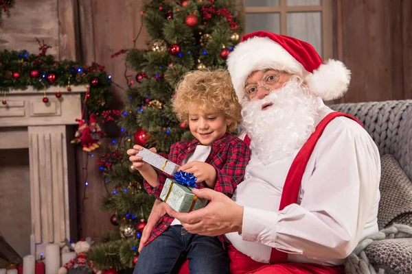 Papá Noel con niño de rodillas - foto de stock