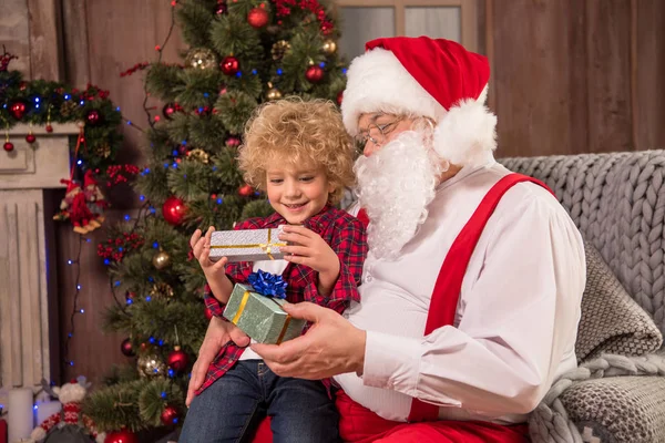Papá Noel con niño de rodillas - foto de stock