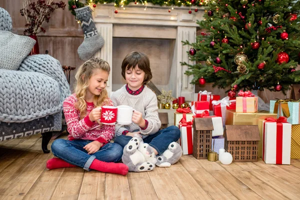 Kinder sitzen in der Nähe von Geschenkboxen — Stockfoto