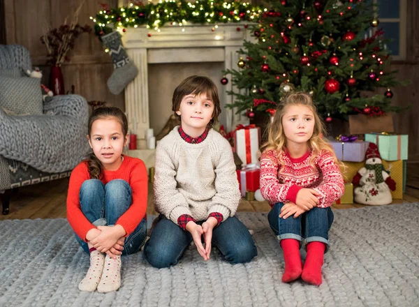 Kids sitting on grey carpet — Stock Photo