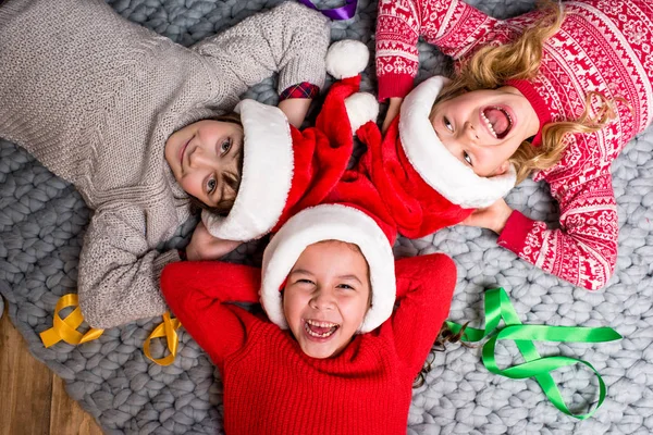 Kids in Santa hats lying in circle — Stock Photo