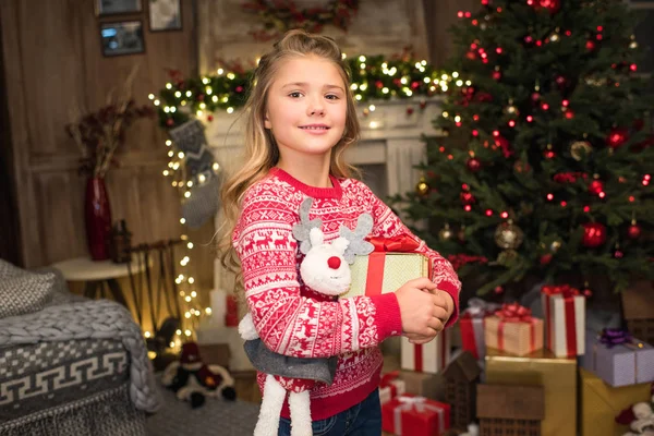 Kid smiling at camera with gift box — Stock Photo