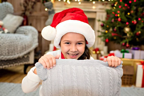 Bambino in cappello Babbo Natale che tiene cuscino — Foto stock