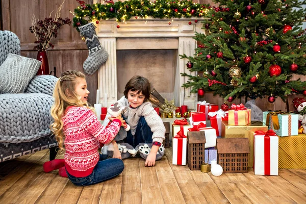 Kinder sitzen in der Nähe von Geschenkboxen — Stockfoto