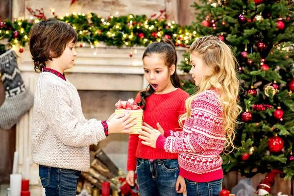 Kid giving gift box to friends — Stock Photo