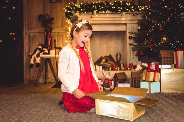 Mädchen öffnet Weihnachtsgeschenk — Stockfoto