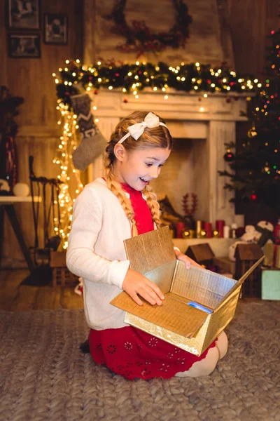 Mädchen öffnet Weihnachtsgeschenk — Stockfoto