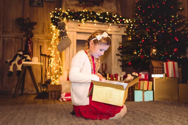 Mädchen öffnet Weihnachtsgeschenk — Stockfoto