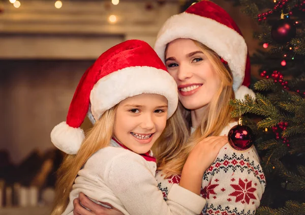 Mère et fille heureuses dans des chapeaux de Père Noël — Photo de stock