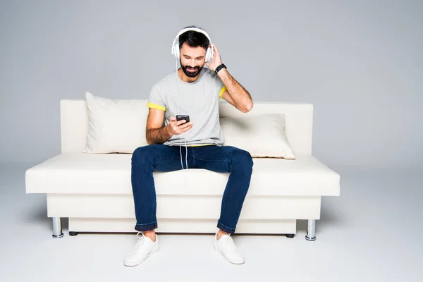 Homem barbudo em fones de ouvido brancos — Fotografia de Stock