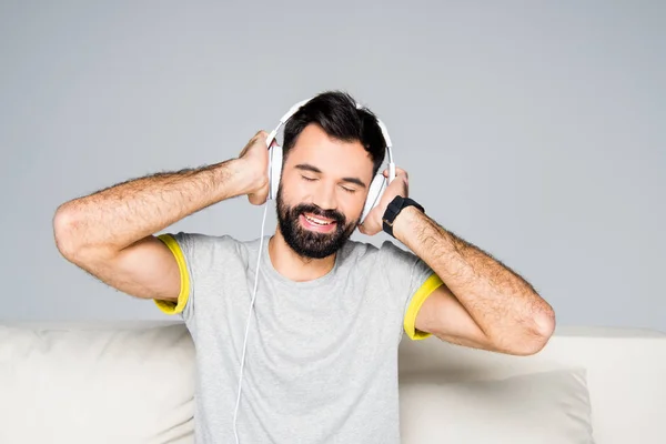 Homem barbudo em fones de ouvido brancos — Fotografia de Stock