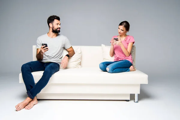 Pareja usando teléfonos inteligentes - foto de stock