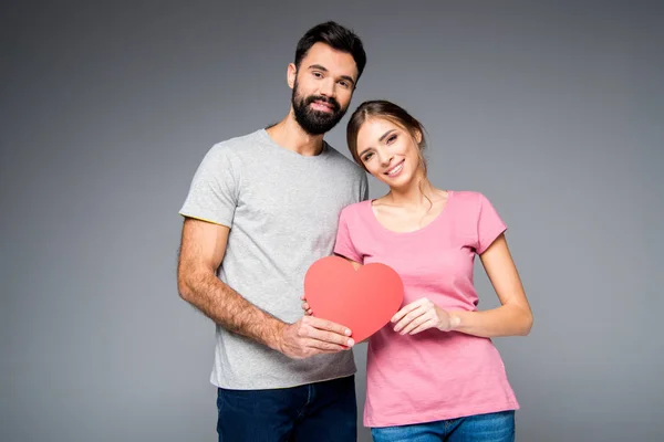 Jeune couple avec coeur rouge — Photo de stock