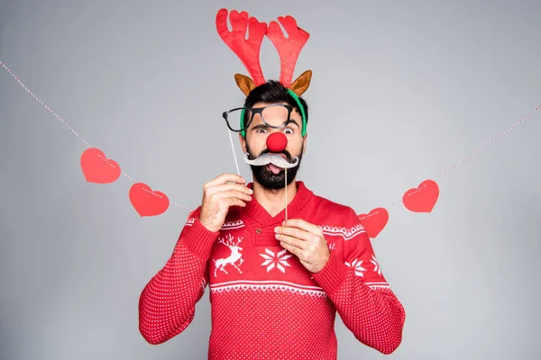 Man in antlers holding party sticks — Stock Photo