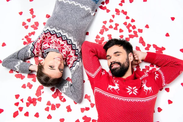 Pareja acostada con corazones - foto de stock