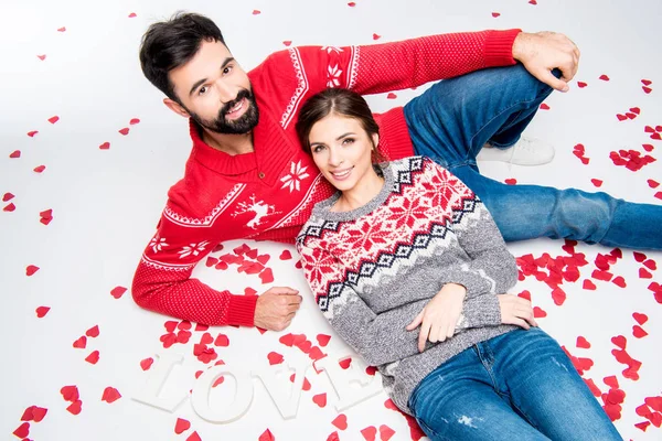 Couple lying together with hearts — Stock Photo