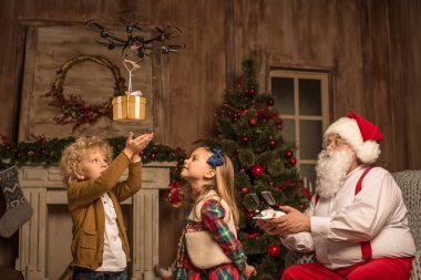 Santa Claus with children using hexacopter drone   clipart