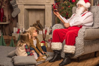 Santa Claus with children reading wishlist  clipart