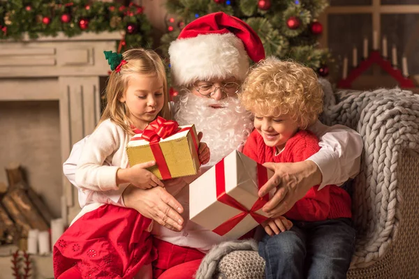 Jultomte med barn hålla presentaskar — Stockfoto