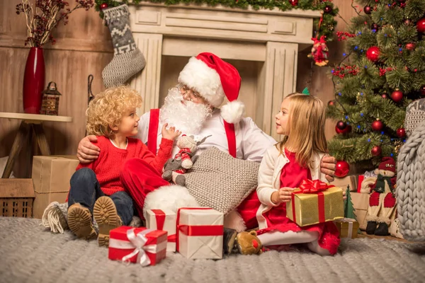 Santa Claus and children with Christmas gifts — Stock Photo, Image