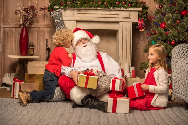 Santa Claus and children with Christmas gifts — Stock Photo, Image