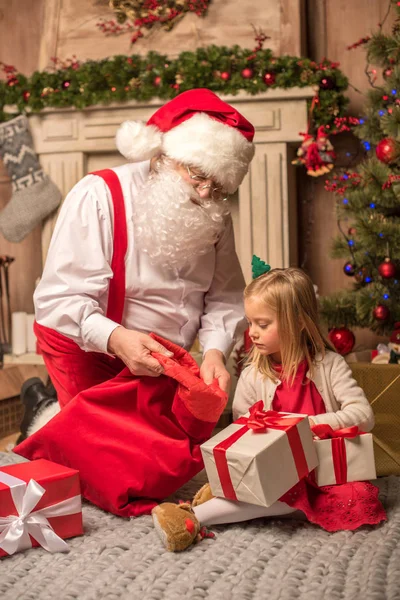 Санта-Клаус показывает рождественские подарки — стоковое фото
